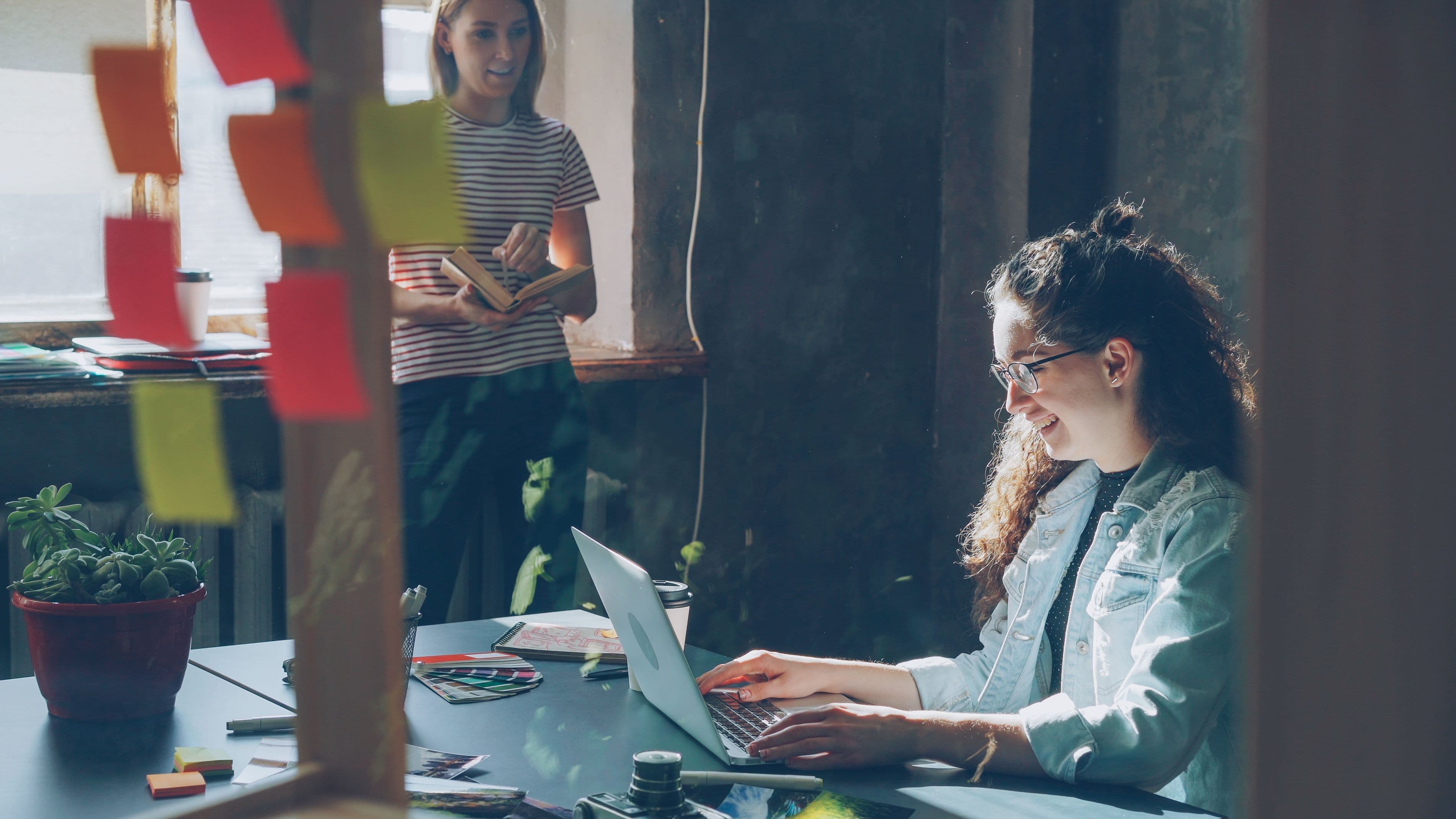 Two people developing ideas together in a sunlit studio